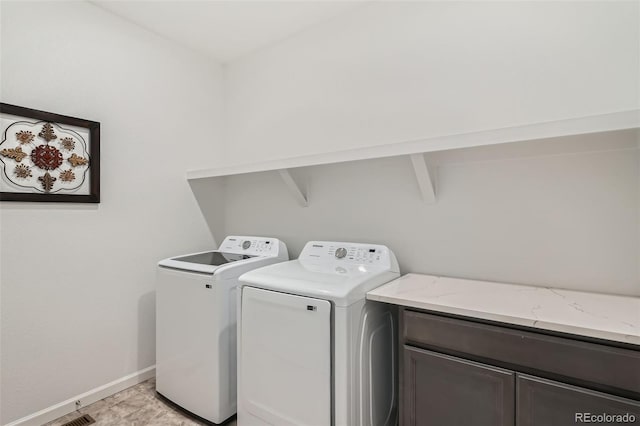 laundry area with baseboards, washer and dryer, and cabinet space