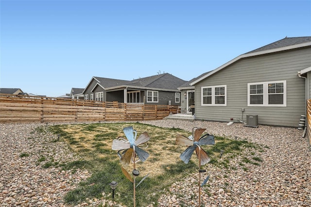 back of property featuring fence and central AC