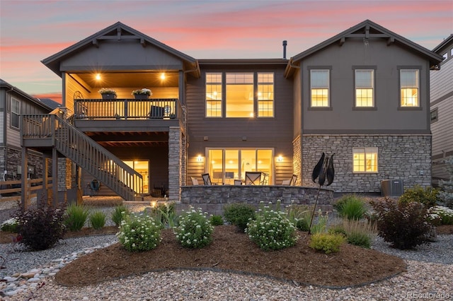 back house at dusk featuring central AC