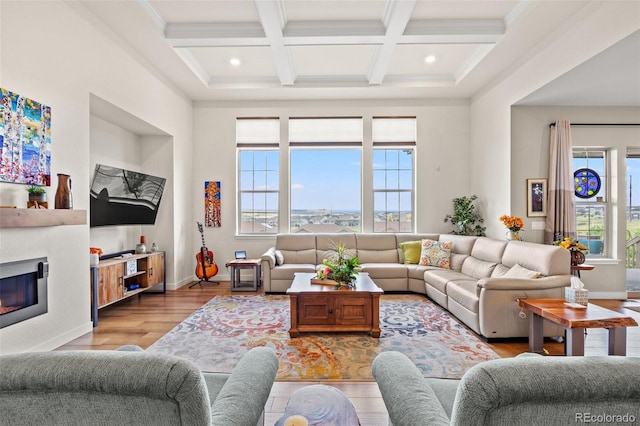 living room with coffered ceiling, light wood-type flooring, crown molding, and beam ceiling