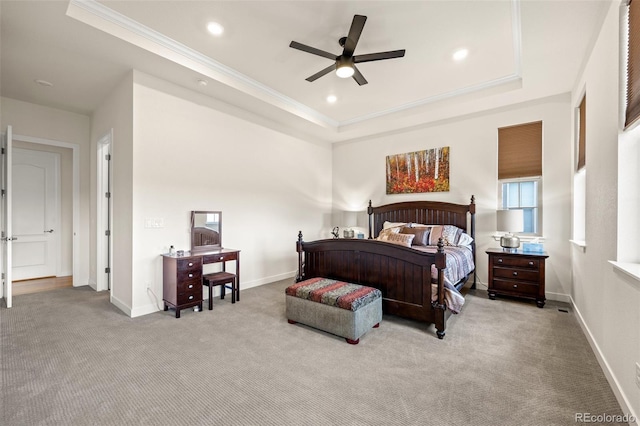 bedroom with crown molding, light colored carpet, a raised ceiling, and ceiling fan