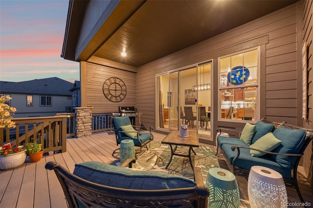 deck at dusk featuring area for grilling and an outdoor living space