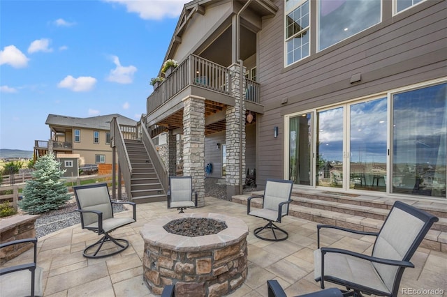 view of patio / terrace with a balcony and an outdoor fire pit