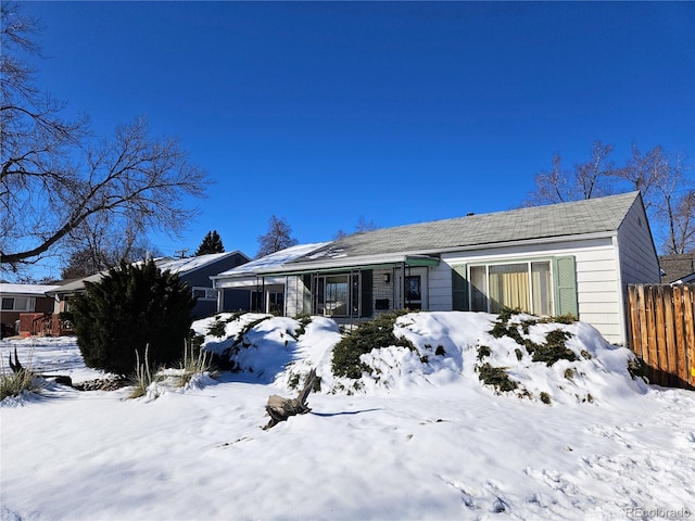 snow covered house with fence