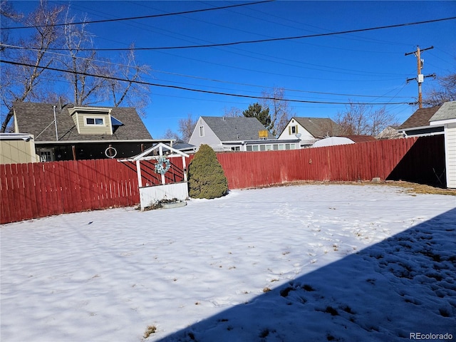 yard layered in snow with fence private yard