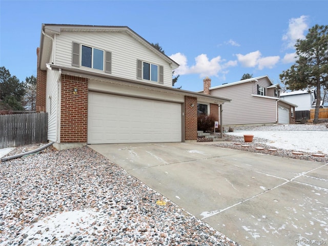 view of front of property featuring driveway, brick siding, an attached garage, and fence