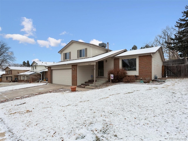 view of front of home featuring driveway, brick siding, and an attached garage