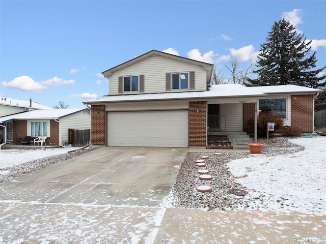 tri-level home featuring concrete driveway, brick siding, and an attached garage