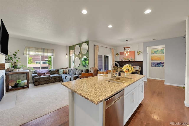 675 W 171st Pl, Broomfield, CO 80023 - kitchen featuring dishwasher, white cabinets, light stone countertops, dark wood-style floors, and a kitchen island with sink