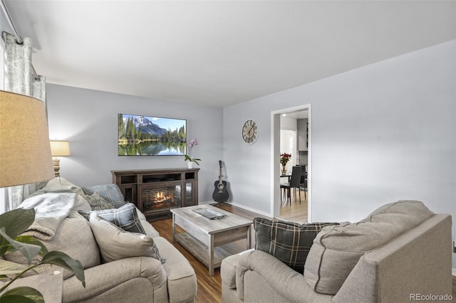 2415 N Logan Ave, Colorado Springs, CO 80907 - living area with wood finished floors, a warm lit fireplace, and baseboards
