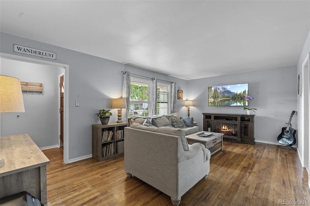 2415 N Logan Ave, Colorado Springs, CO 80907 - living room featuring wood finished floors, a lit fireplace, and baseboards