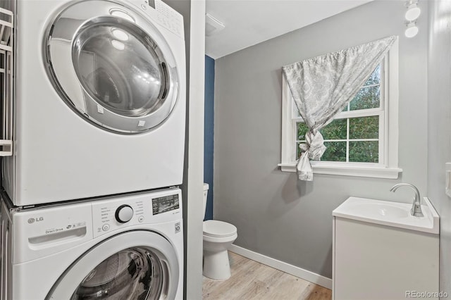 2415 N Logan Ave, Colorado Springs, CO 80907 - washroom with stacked washer / drying machine, light wood-style floors, and baseboards
