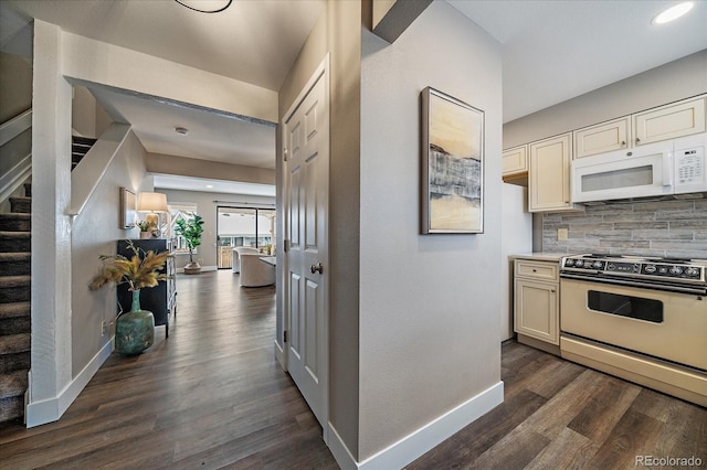 kitchen with backsplash, range, and dark hardwood / wood-style flooring