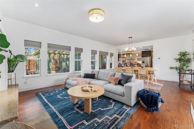 living room with dark wood-type flooring and an inviting chandelier