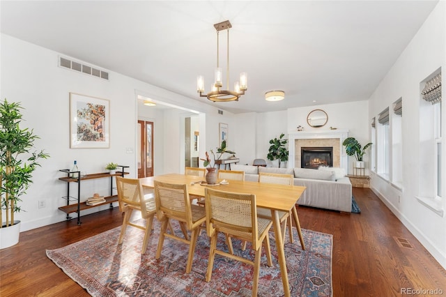 dining area with dark hardwood / wood-style floors and a chandelier