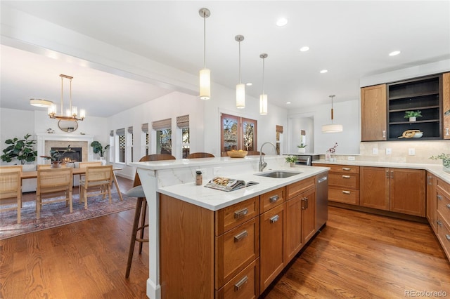 kitchen with sink, decorative light fixtures, a breakfast bar area, and a center island with sink