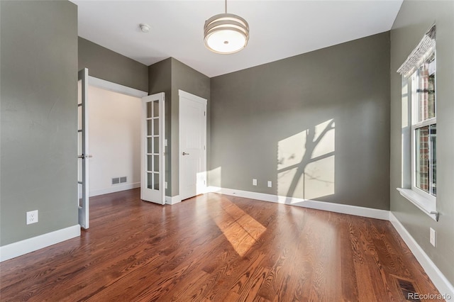 empty room featuring dark hardwood / wood-style floors and french doors