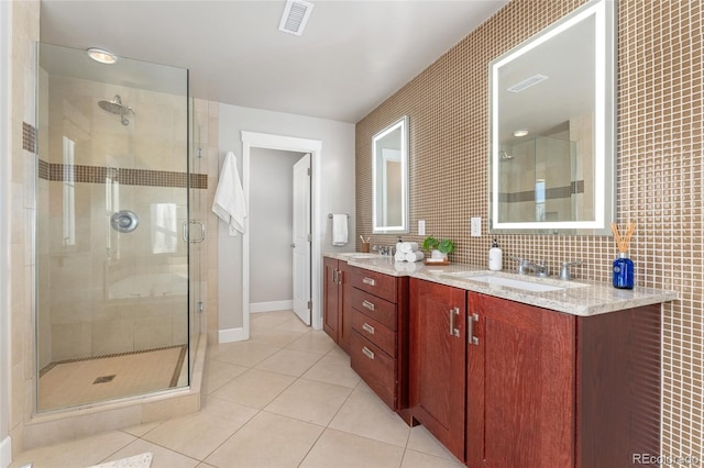 bathroom with tile patterned flooring, tile walls, vanity, decorative backsplash, and a shower with shower door