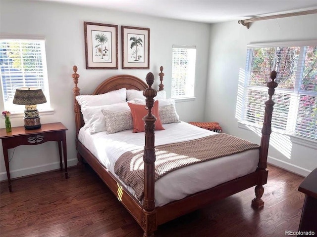 bedroom with multiple windows and dark hardwood / wood-style flooring