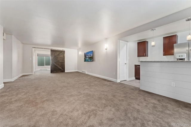 unfurnished living room with light colored carpet and a barn door