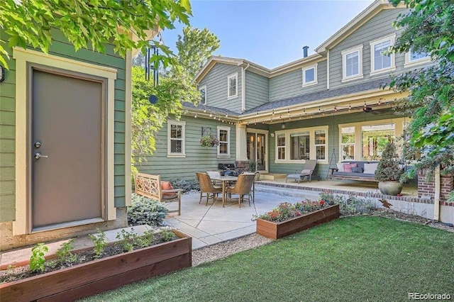 back of property with a lawn and a patio area