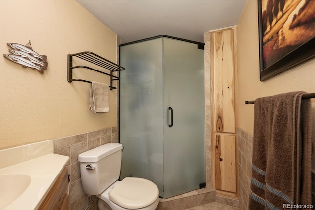 397 County Road 834 Unit 8, Fraser, CO 80442 - bathroom featuring tile walls, a shower stall, toilet, vanity, and wainscoting