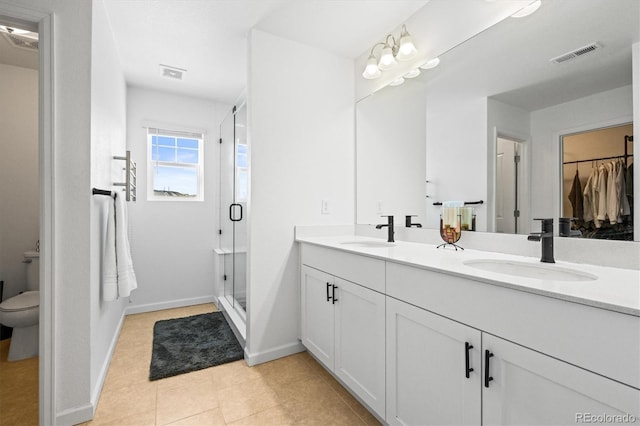 bathroom with toilet, a shower with door, vanity, and tile patterned floors