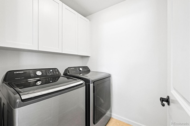 laundry room with washer and dryer, cabinets, and light tile patterned floors