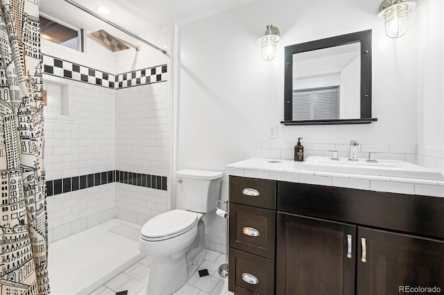 bathroom with toilet, vanity, tile patterned floors, and curtained shower