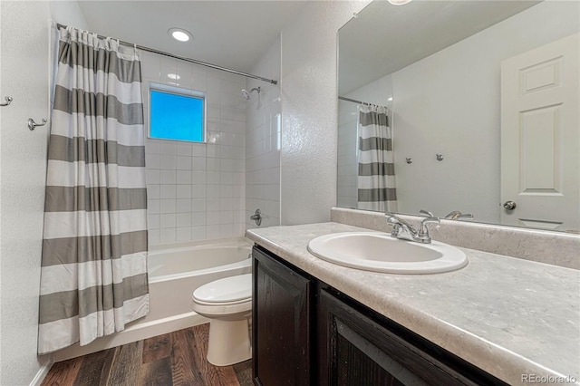 bathroom with a textured wall, toilet, wood finished floors, vanity, and shower / bathtub combination with curtain