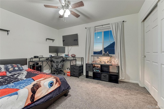 carpeted bedroom with a textured ceiling, a ceiling fan, and baseboards