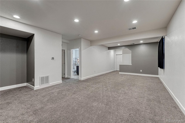 below grade area with carpet, visible vents, and baseboards