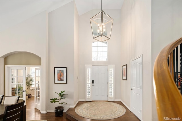 entrance foyer with an inviting chandelier, dark hardwood / wood-style flooring, and high vaulted ceiling