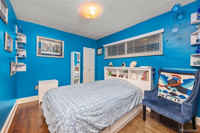 2514 N Humboldt St, Denver, CO 80205 - bedroom featuring wood finished floors, a textured ceiling, and baseboards