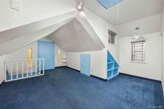 2514 N Humboldt St, Denver, CO 80205 - additional living space with attic access, dark colored carpet, baseboards, and vaulted ceiling