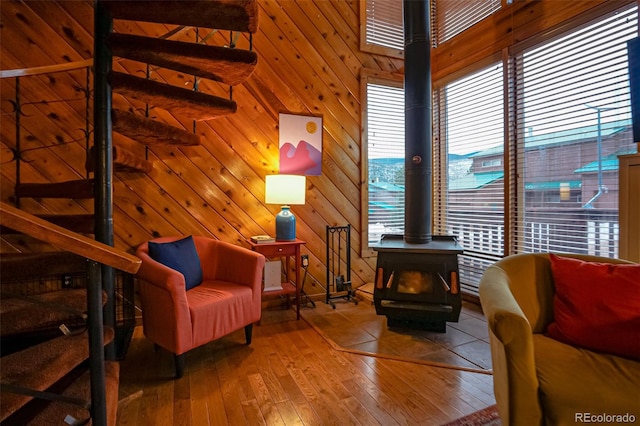 sitting room featuring hardwood / wood-style floors, a high ceiling, and wooden walls