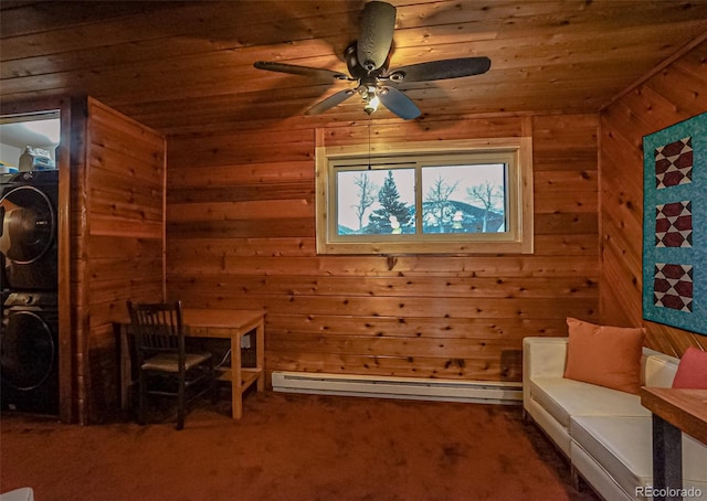 unfurnished room featuring a baseboard heating unit, carpet floors, stacked washer / drying machine, and wood walls