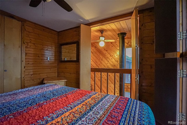 bedroom featuring ceiling fan and wooden walls