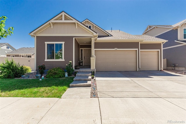 5568 Ceylon St, Denver, CO 80249 - view of front of house featuring a garage, driveway, and board and batten siding