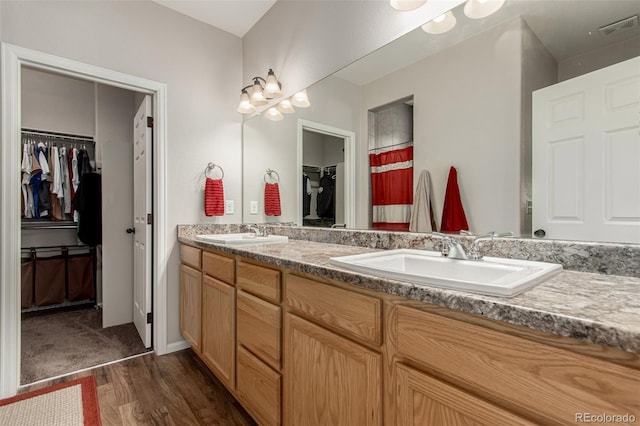 5568 Ceylon St, Denver, CO 80249 - full bath featuring double vanity, a walk in closet, and wood finished floors