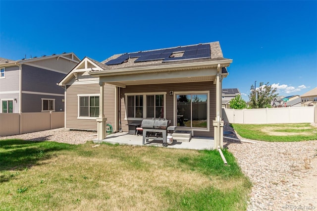 5568 Ceylon St, Denver, CO 80249 - back of property with roof mounted solar panels, a patio, a fenced backyard, an outdoor hangout area, and a shingled roof