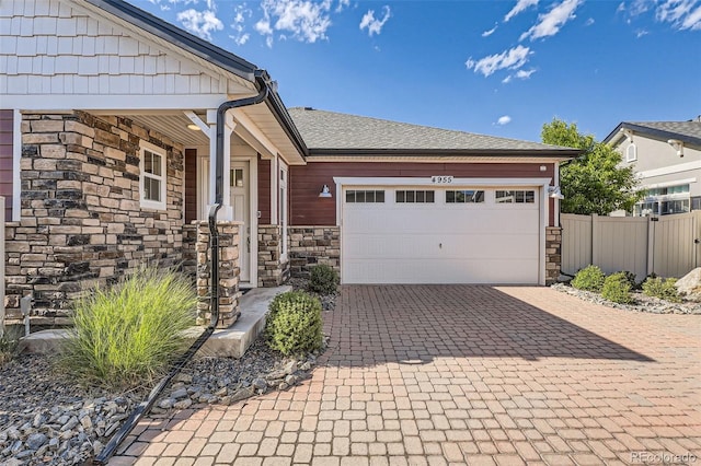 4955 N Picadilly Ct, Aurora, CO 80019 - ranch-style home with stone siding, decorative driveway, and an attached garage