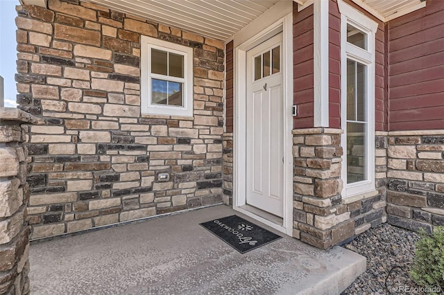 4955 N Picadilly Ct, Aurora, CO 80019 - doorway to property with stone siding and covered porch