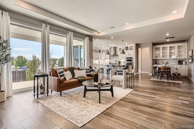 4955 N Picadilly Ct, Aurora, CO 80019 - living room with wood finished floors, a raised ceiling, and recessed lighting