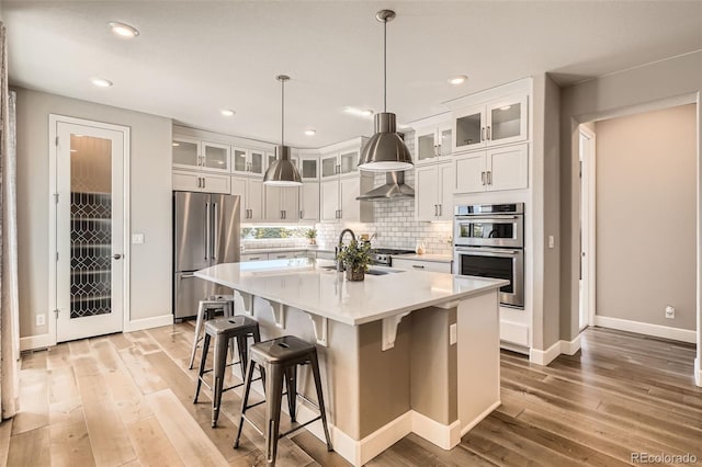 4955 N Picadilly Ct, Aurora, CO 80019 - kitchen featuring stainless steel appliances, a sink, light wood-style flooring, tasteful backsplash, and recessed lighting