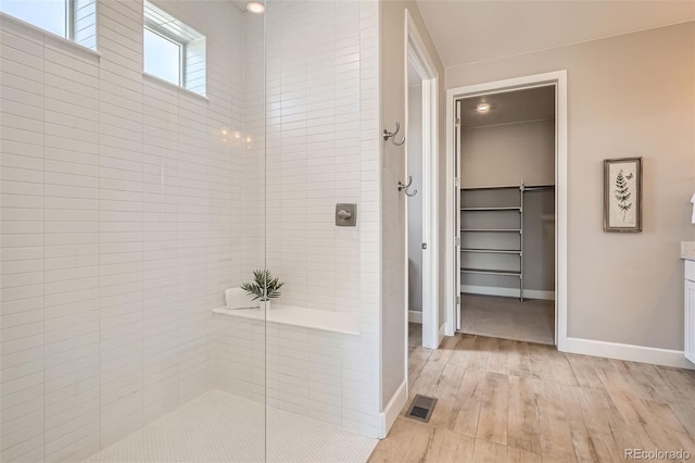 4955 N Picadilly Ct, Aurora, CO 80019 - full bath with a walk in closet, wood finished floors, walk in shower, vanity, and baseboards