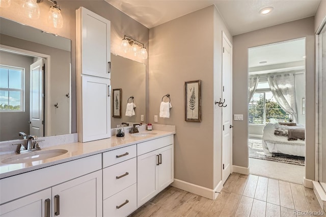 4955 N Picadilly Ct, Aurora, CO 80019 - ensuite bathroom featuring double vanity, wood finished floors, baseboards, and recessed lighting
