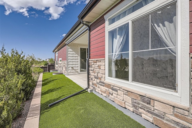 4955 N Picadilly Ct, Aurora, CO 80019 - view of side of property featuring stone siding and a patio