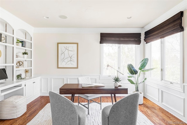office featuring a wainscoted wall, ornamental molding, wood finished floors, and a wealth of natural light