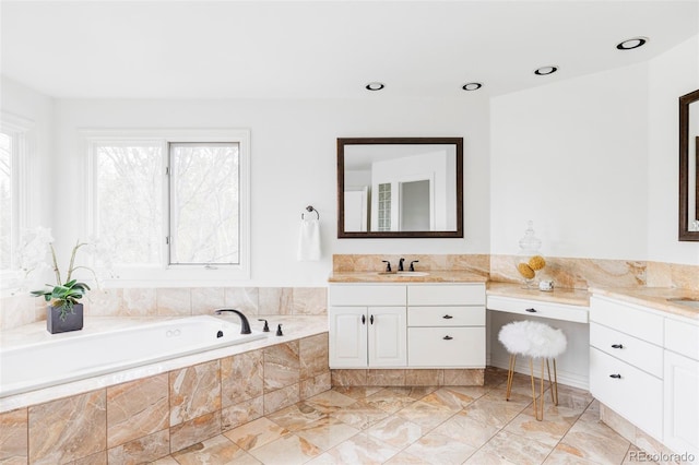 bathroom featuring vanity, marble finish floor, and a bath